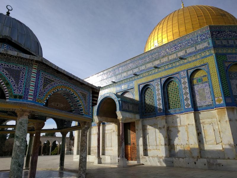 Golden dome, vibrant tiles, and elegant Arabic calligraphy